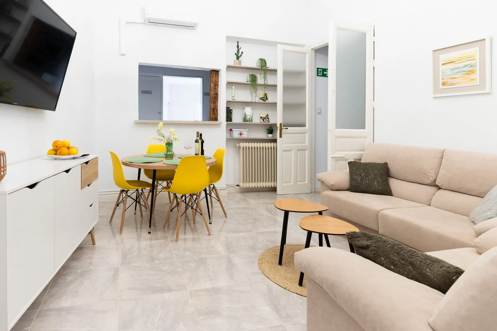 Salón de El Refugio con sofá, mesa de comedor y sillas amarillas