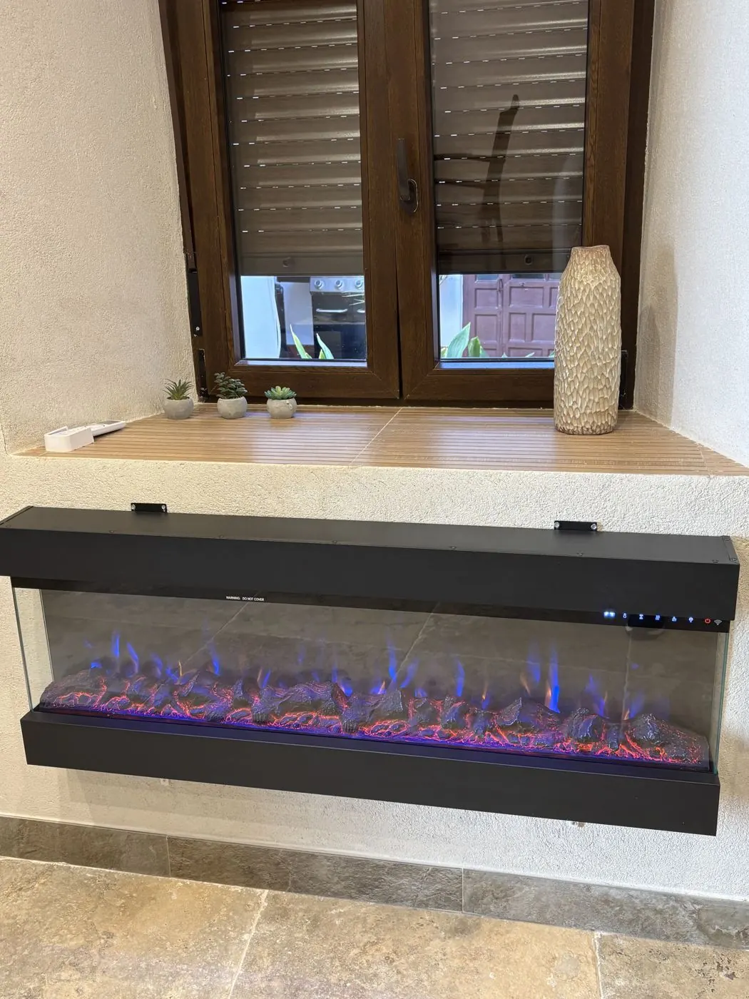 Chimenea eléctrica del salón bajo la ventana